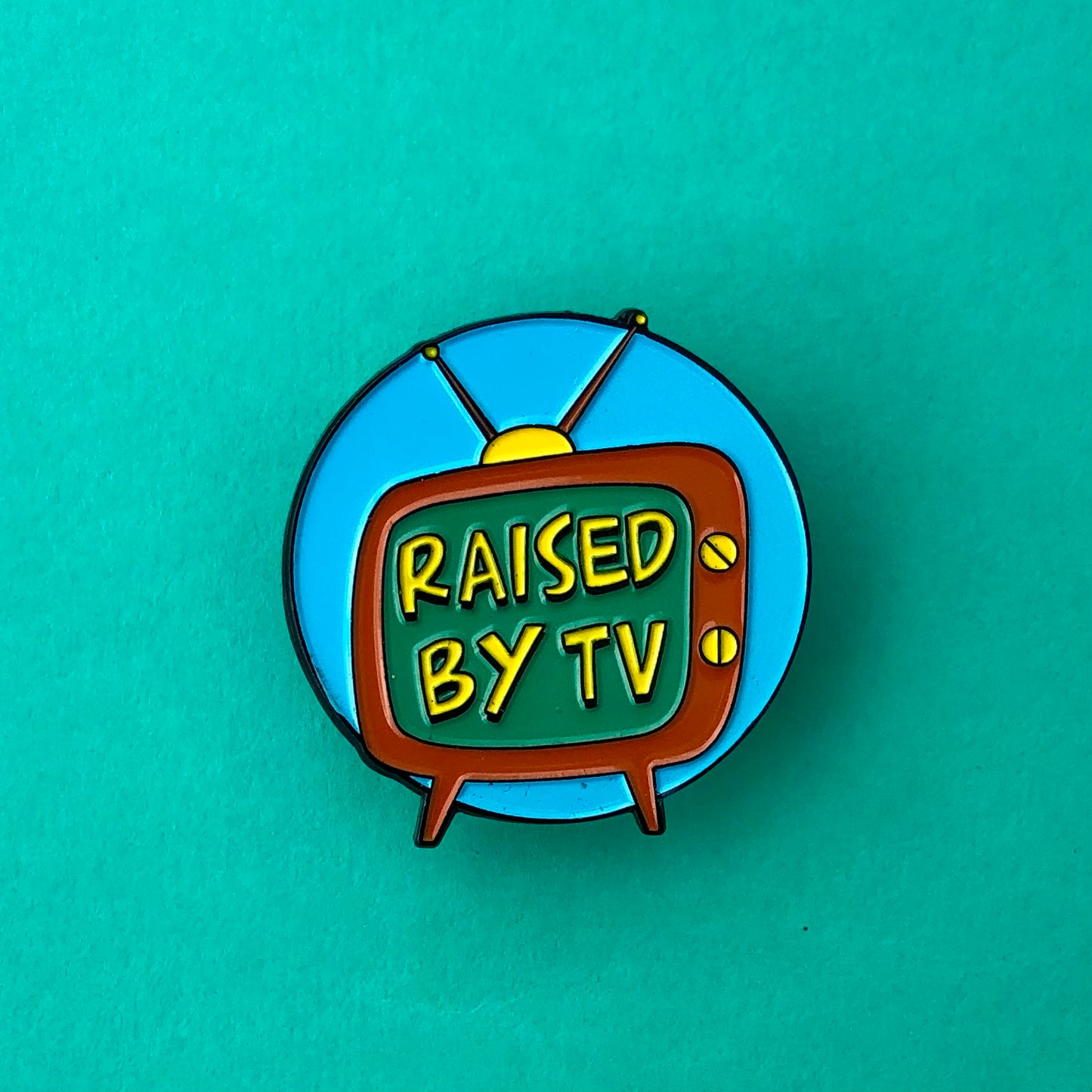 Raised by TV Enamel Pin