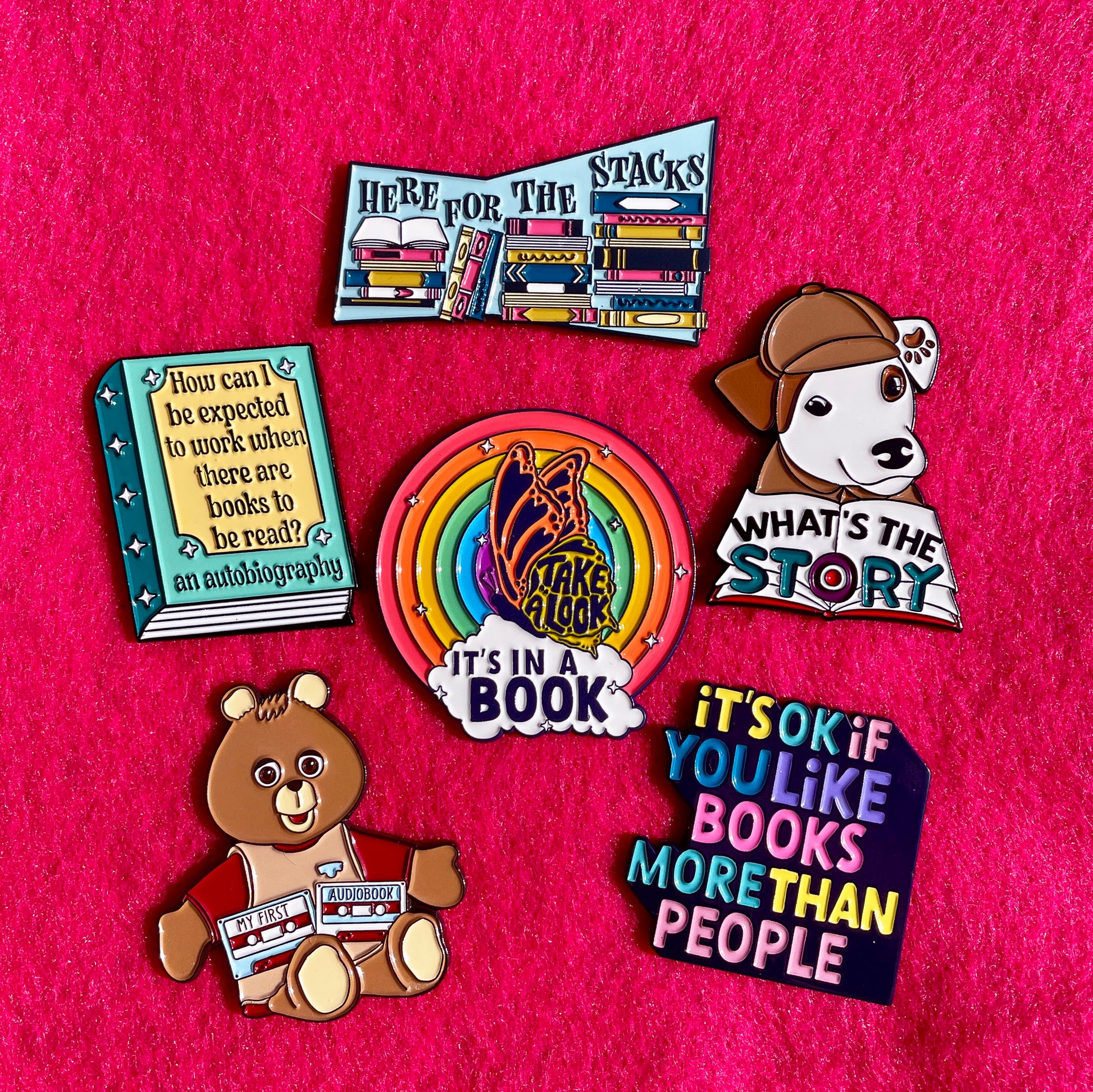 Collection of book-themed pins on a pink background wishbone reading rainbow teddy ruxpin