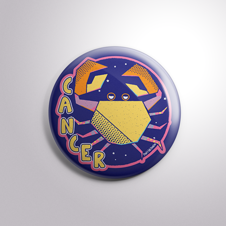 Button badge with a zodiac cancer design on a light gray background