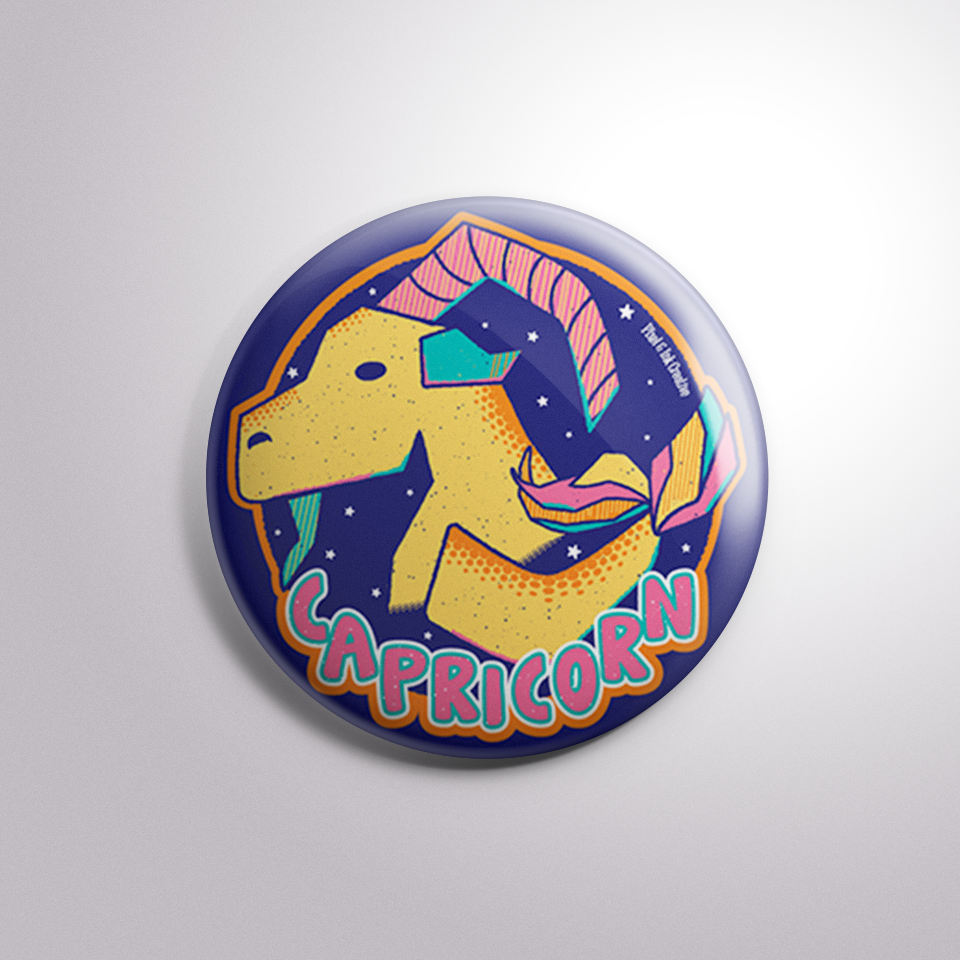 Button badge with Capricorn zodiac sign design on a light gray background